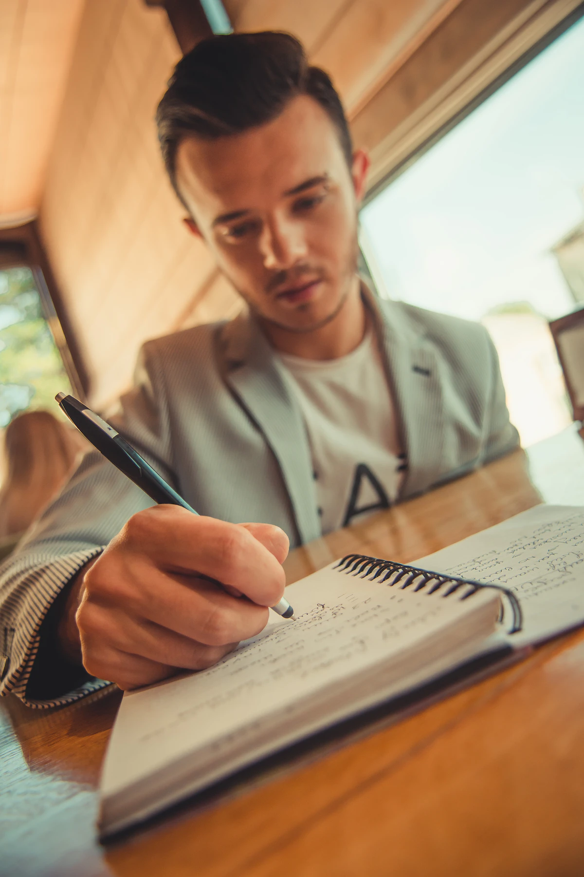 A man writing entries in a notebook