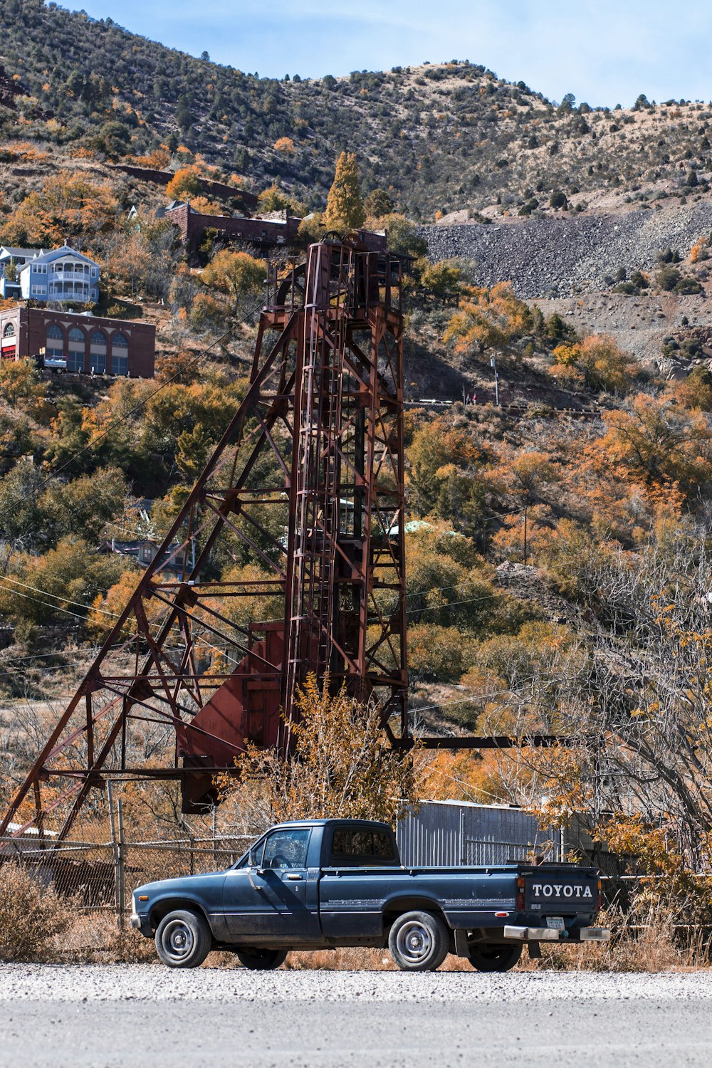 black single-cab pickup truck beside red metal frame during daytime