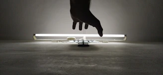 silhouette of person's hand near fluorescent lamp