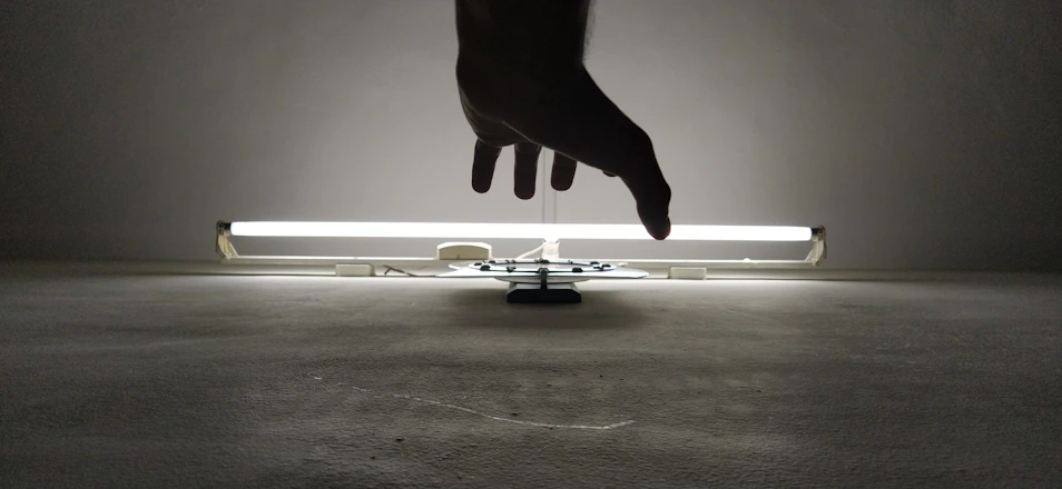 silhouette of person's hand near fluorescent lamp