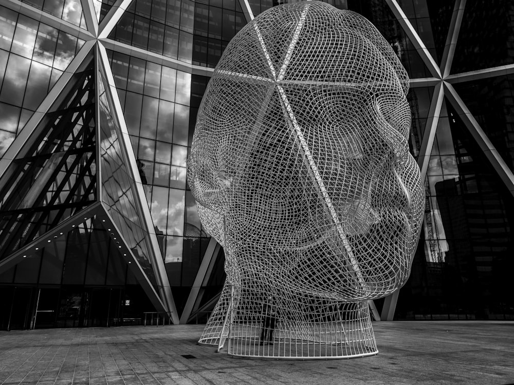 a black and white photo of a sculpture in front of a building