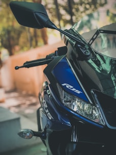 A clear motorcycle windscreen mounted on a bike, highlighting its aerodynamic shape against a blurred road background.