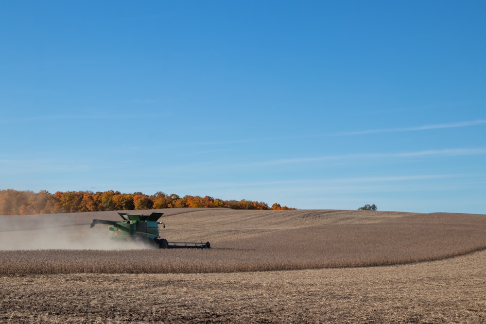 gray heavy equipment on brown field during daytime