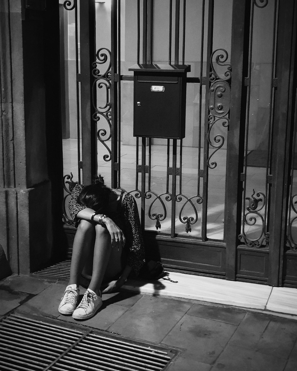 woman sitting beside closed door