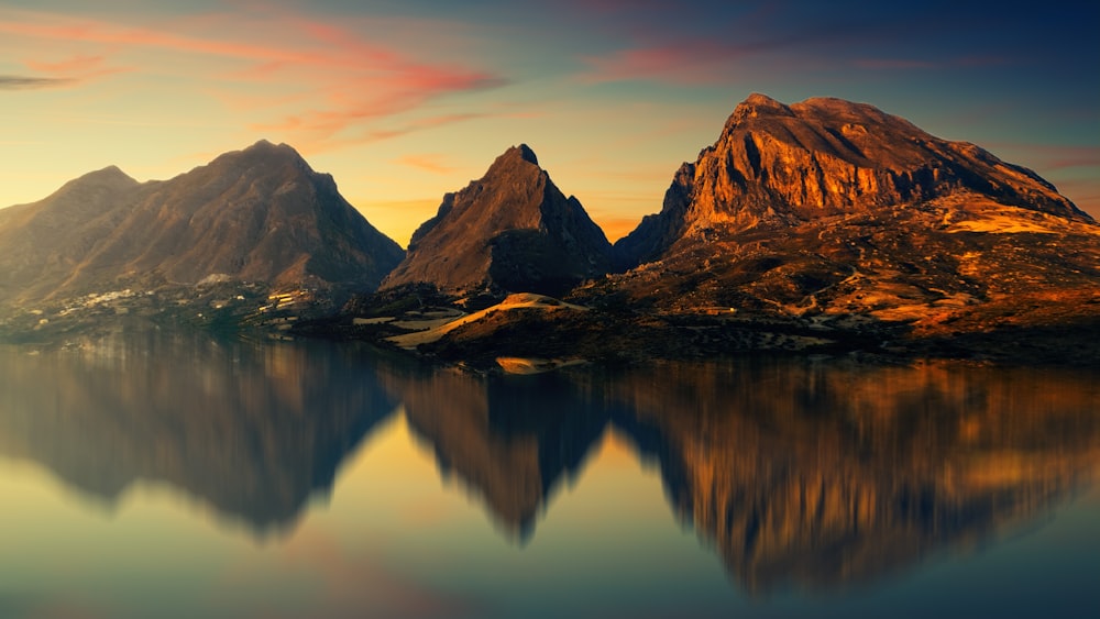 calm body of water surrounded by mountains