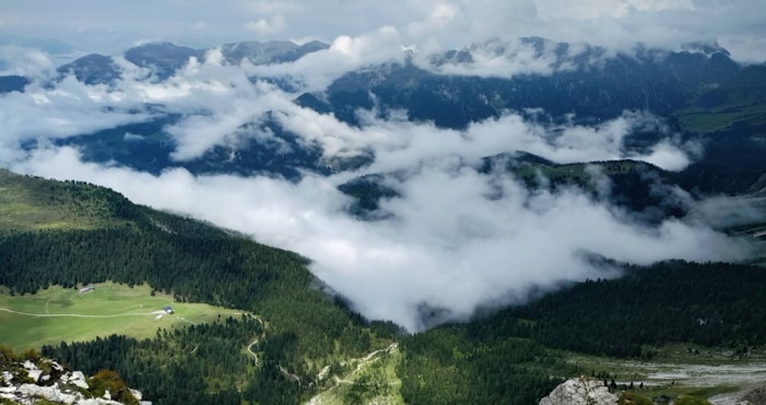 A breathtaking view of lush green mountains with a misty backdrop, symbolizing the beauty of Rwanda's landscapes.