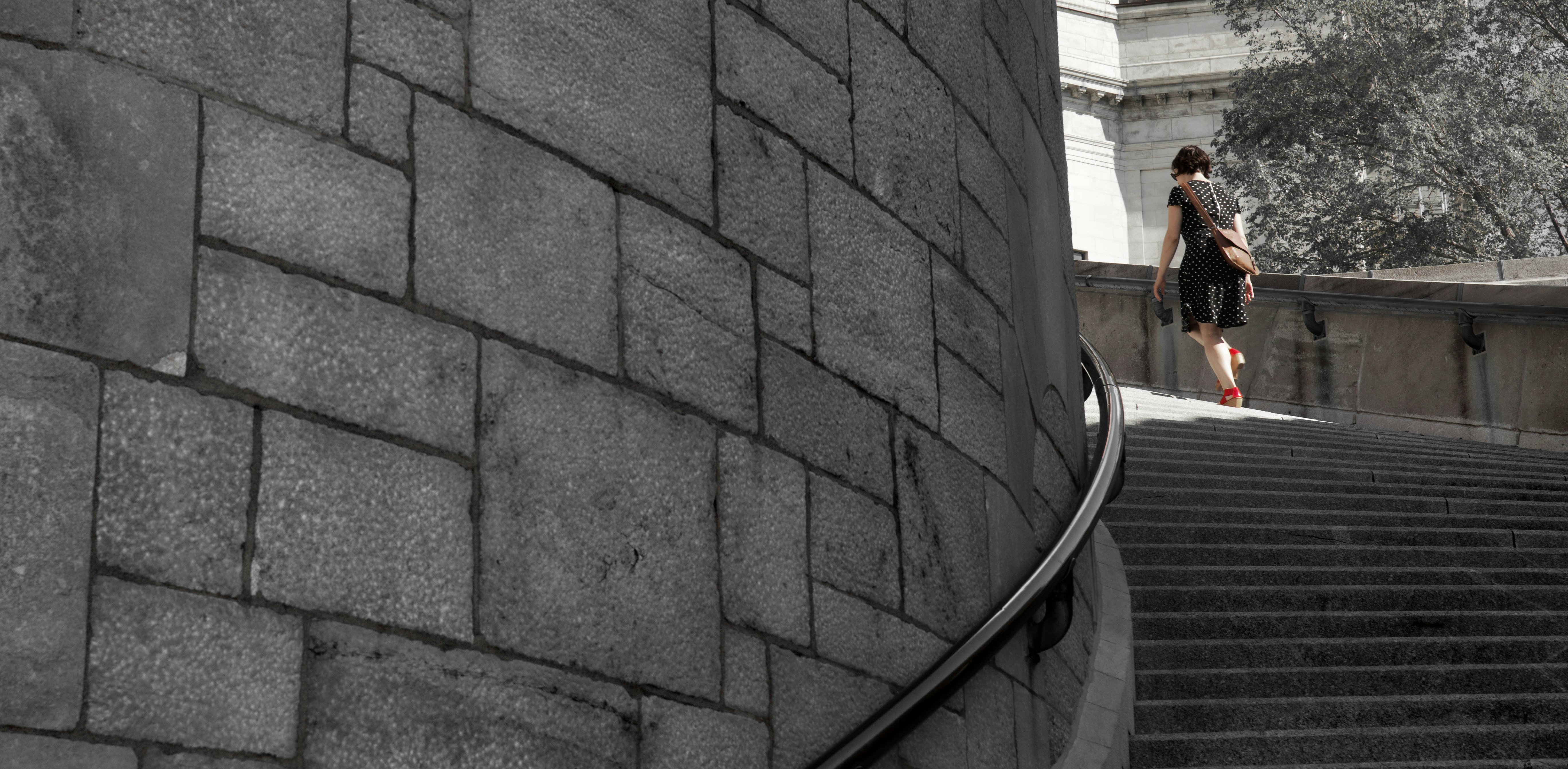 Woman with red shoes walking up circular stairs
