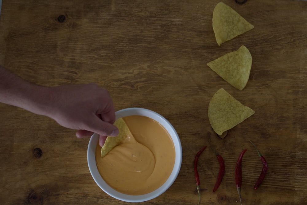 personne trempant des chips