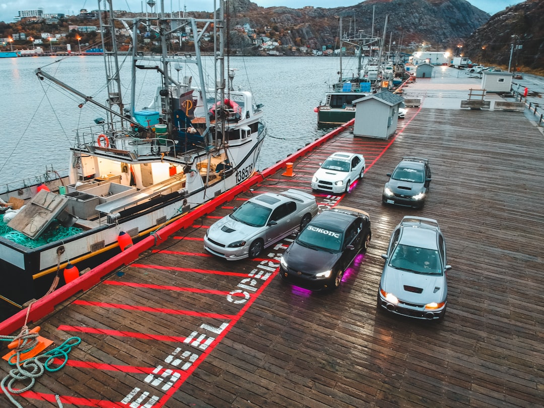 five vehicles on wooden dock near body of water