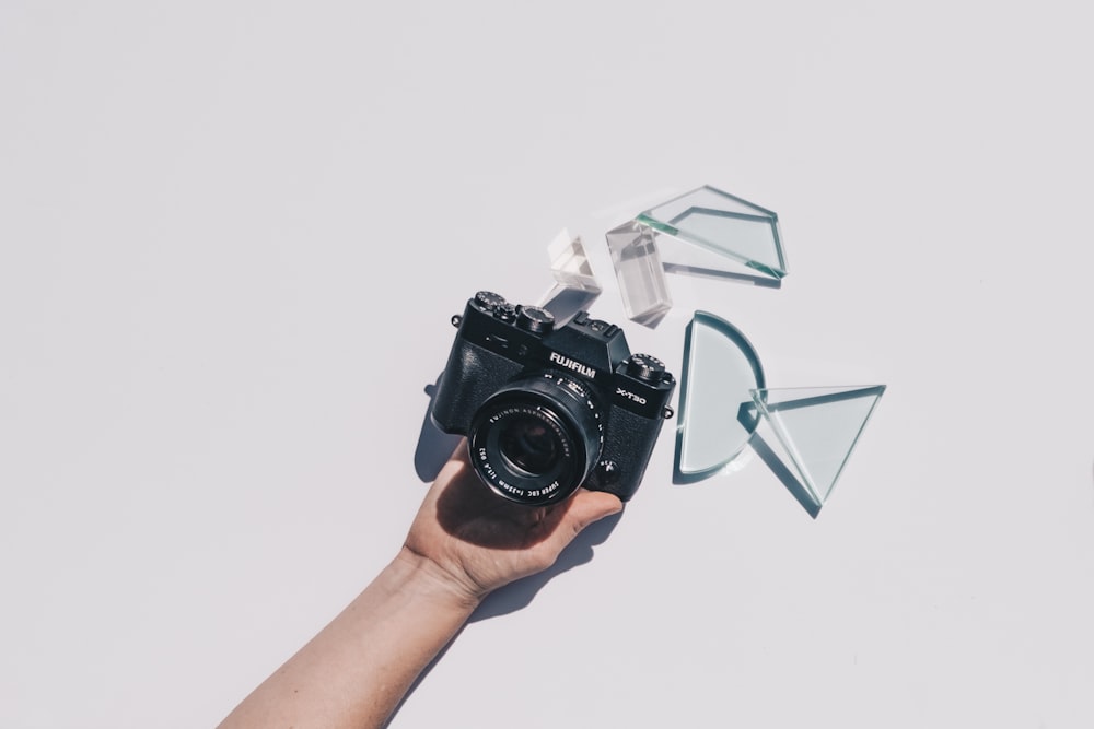 person holding black DSLR camera