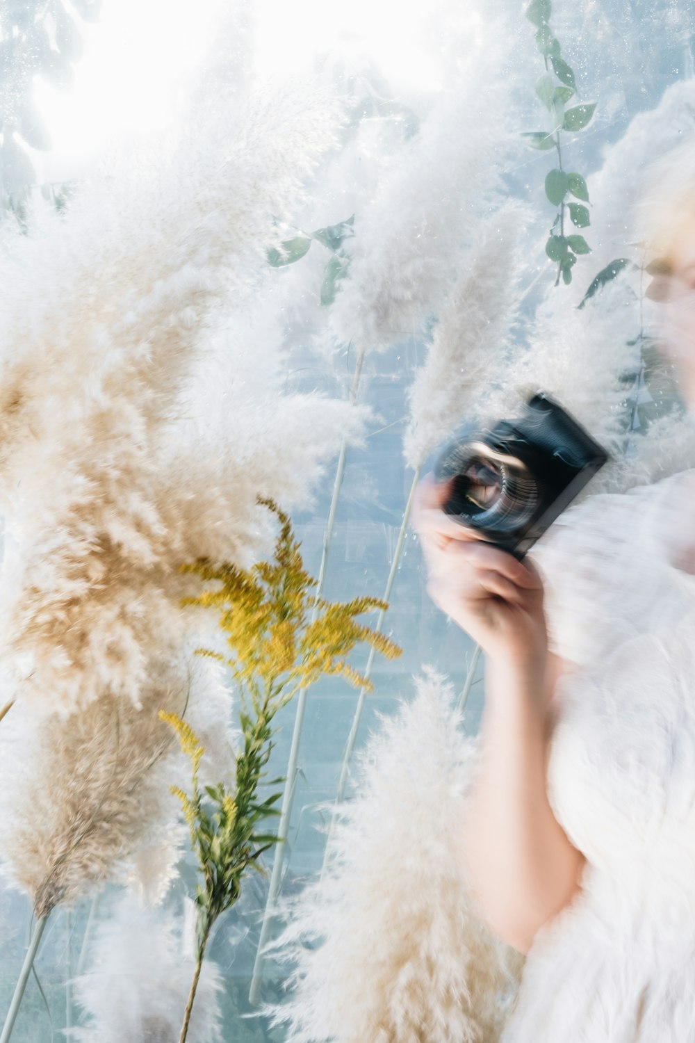 woman wearing white dress holding black camera