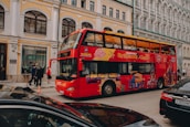 a red double decker bus driving down a street