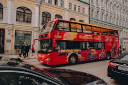 a red double decker bus driving down a street