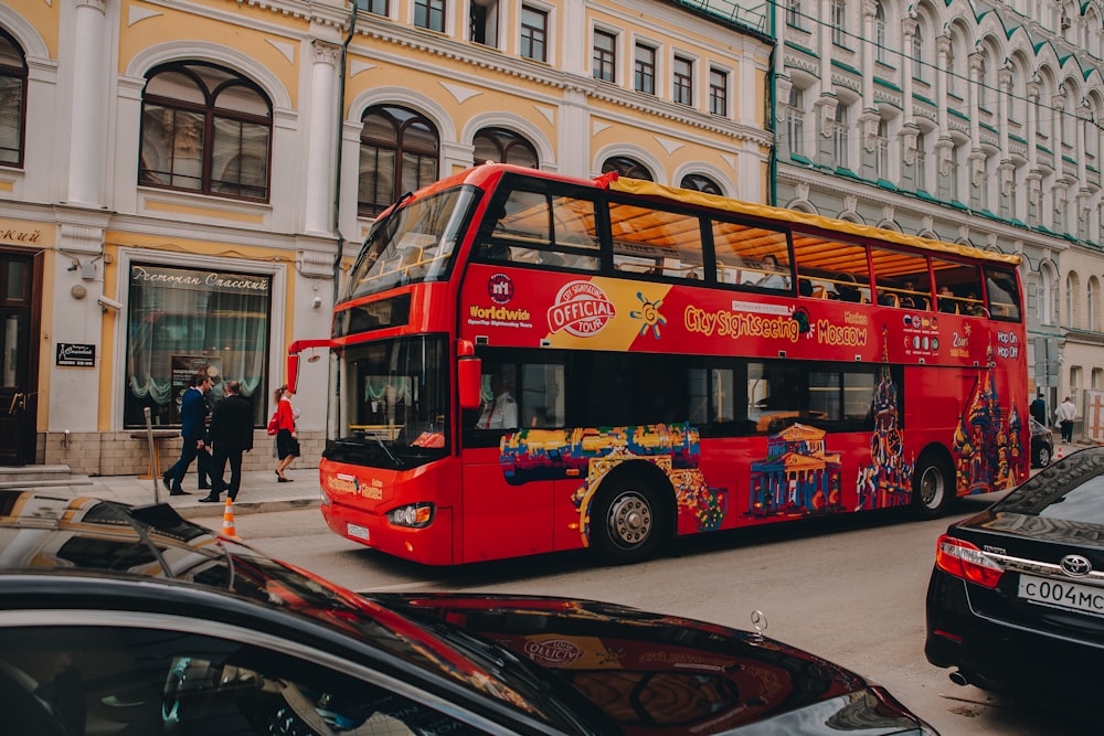 a red double decker bus driving down a street