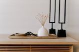 white ceramic vase near two black table decors