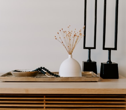 white ceramic vase near two black table decors