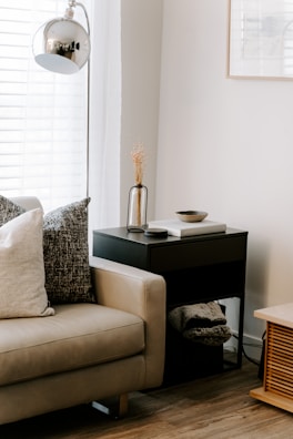 A cozy living room corner featuring a soft throw pillow and a rustic wooden side table.