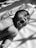 grayscale photo of baby on bed