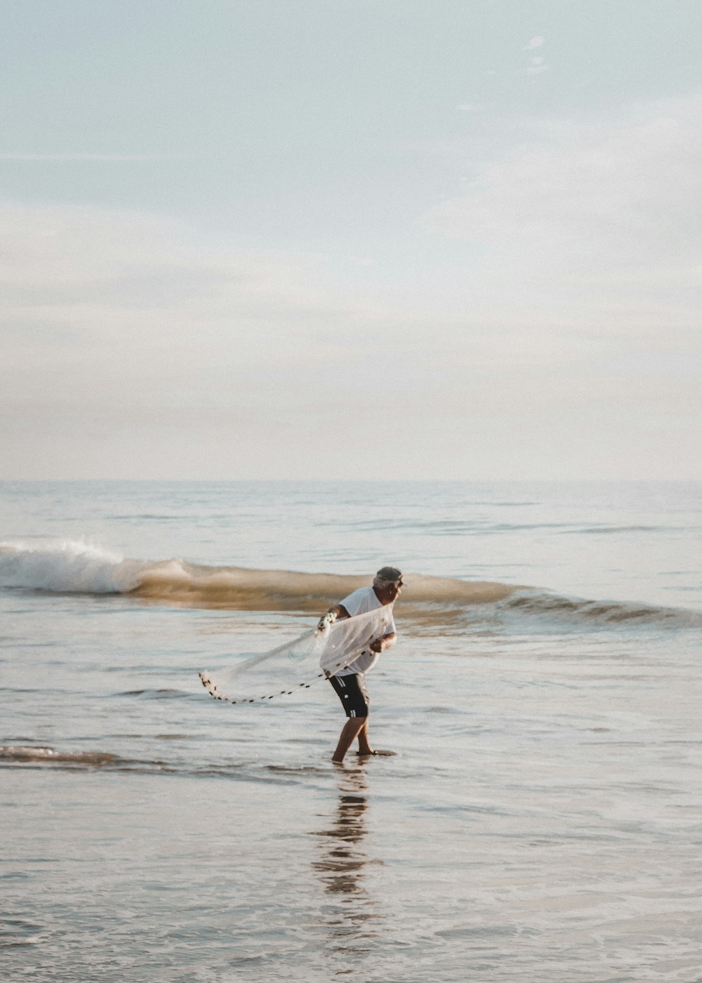 person holding net on seashore