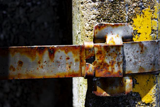 Close-up of a stainless steel hinge with industrial background