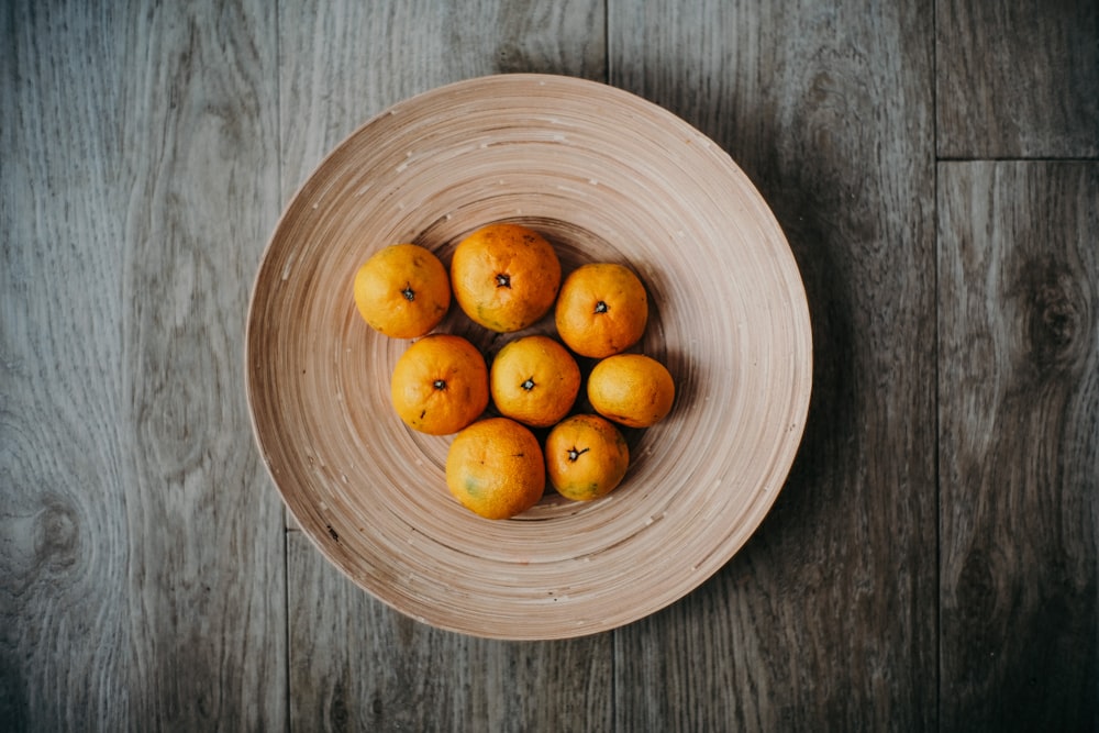 round orange fruits on round bowl