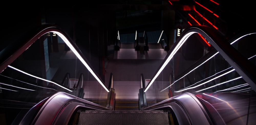 an escalator in a building with lights on it