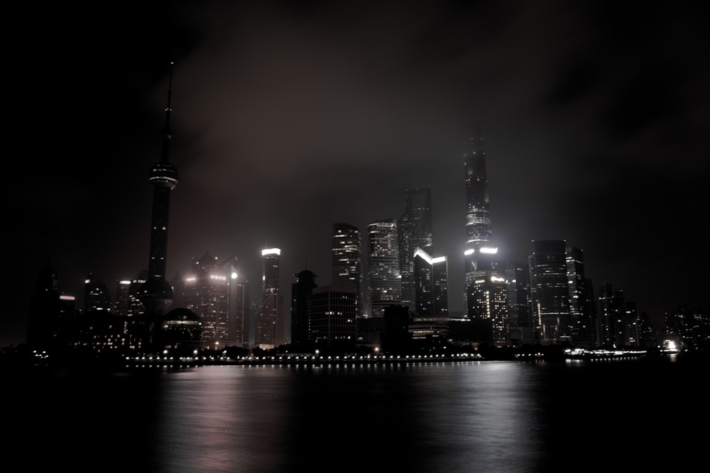 a city skyline at night with lights reflecting off the water