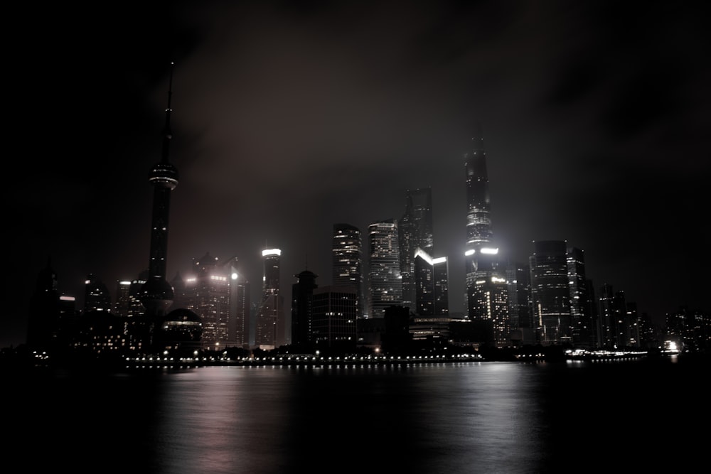 um horizonte da cidade à noite com luzes refletindo na água