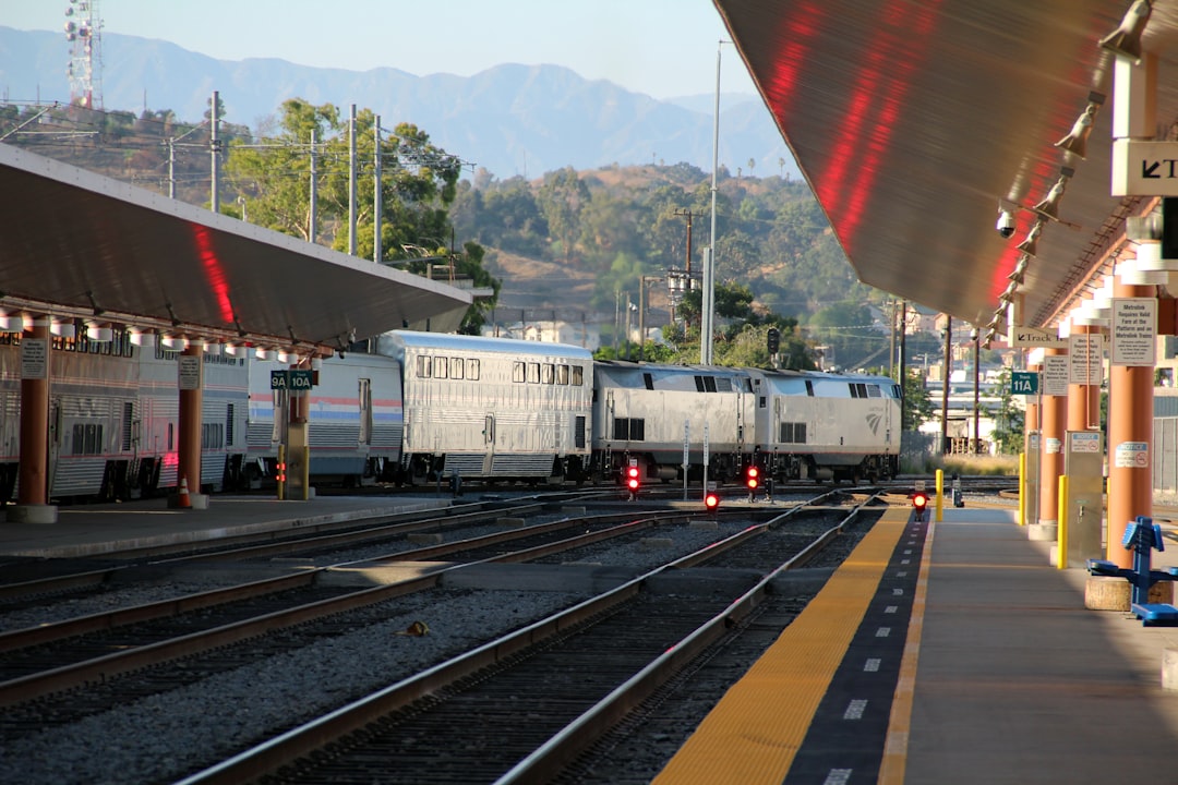 white vehicle on road, An Amtrak train bound for Chicago departs Los Angeles Union Station.
