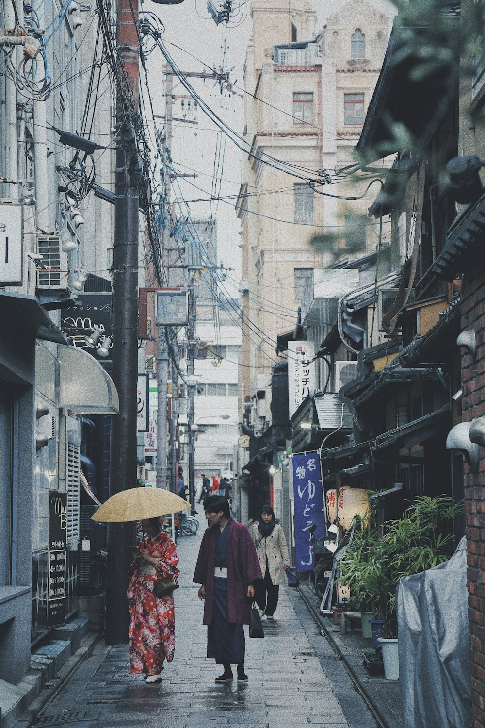 man and woman walking on street in line of buildings