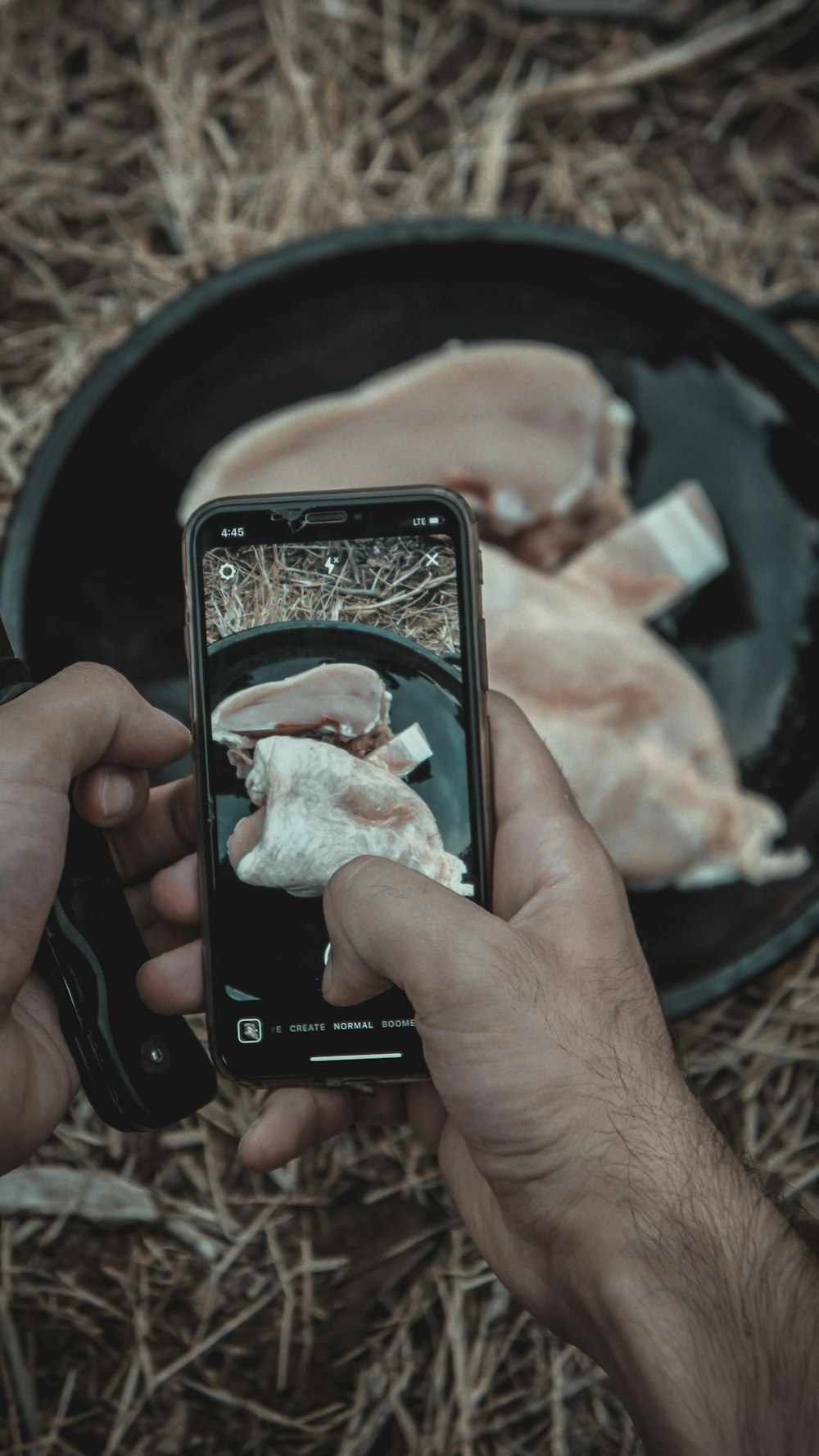 person taking photo of meat