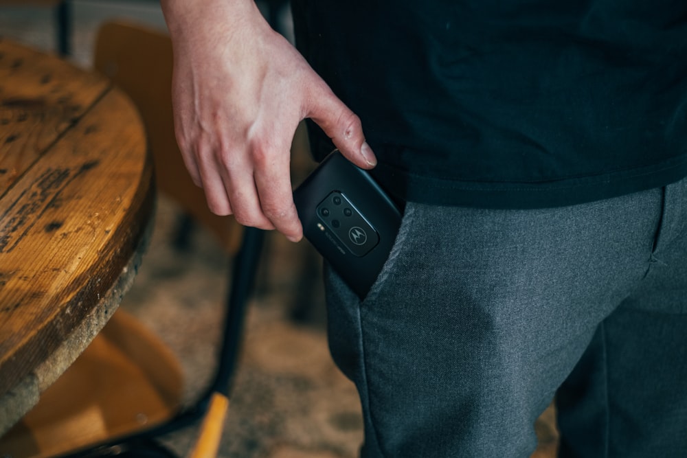 pessoa inserindo smartphone no bolso
