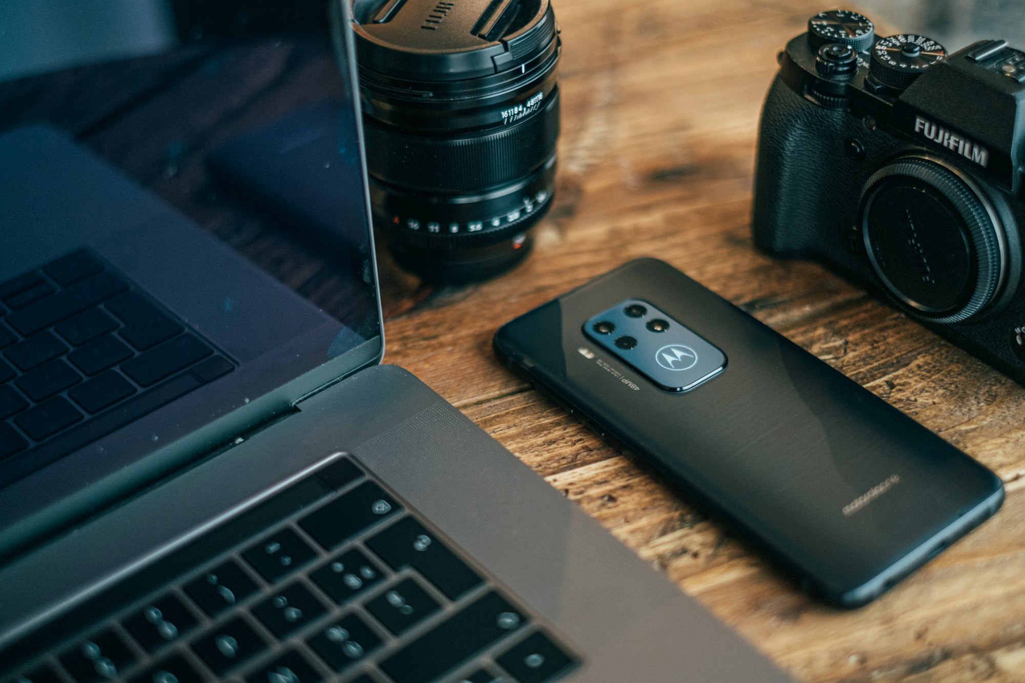 Motorola One Zoom smartphone on a table, next to the Fujifilm XT-3 and a Macbook Pro. Picture by Jonas Leupe (www.brandstof.studio) for Tandem Tech