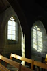 Sunlight filtering through stained glass in a historic venue hosting the association's cultural event.