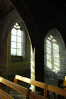 Sunlight filtering through stained glass in a historic venue hosting the association's cultural event.