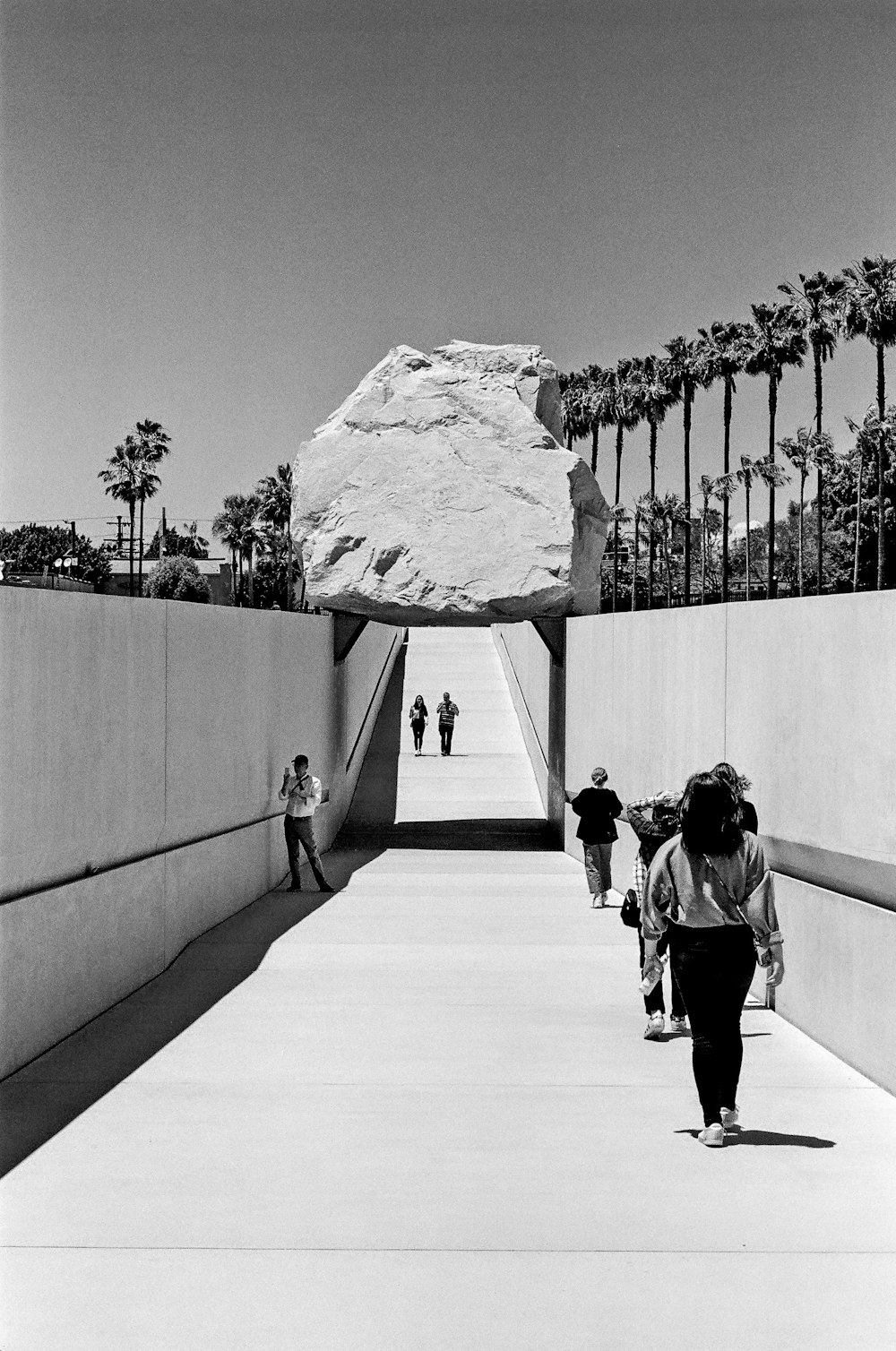 grayscale photo of people on bridge