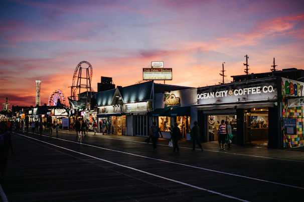 Sunset view over a bustling Myrtle Beach boardwalk with colorful shops and the iconic SkyWheel.
