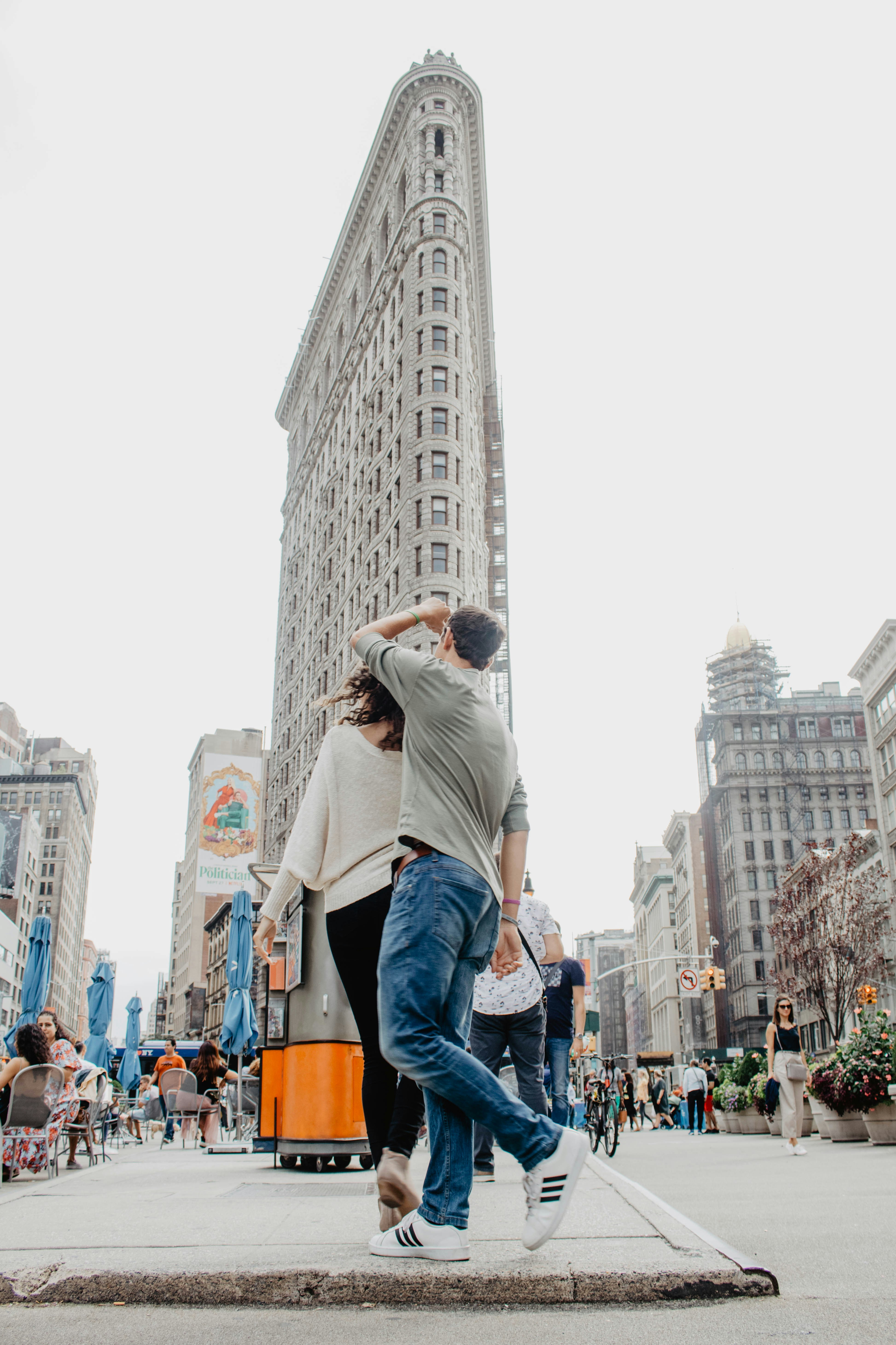 낮에 회색 콘크리트 건물 근처를 걷는 사람들