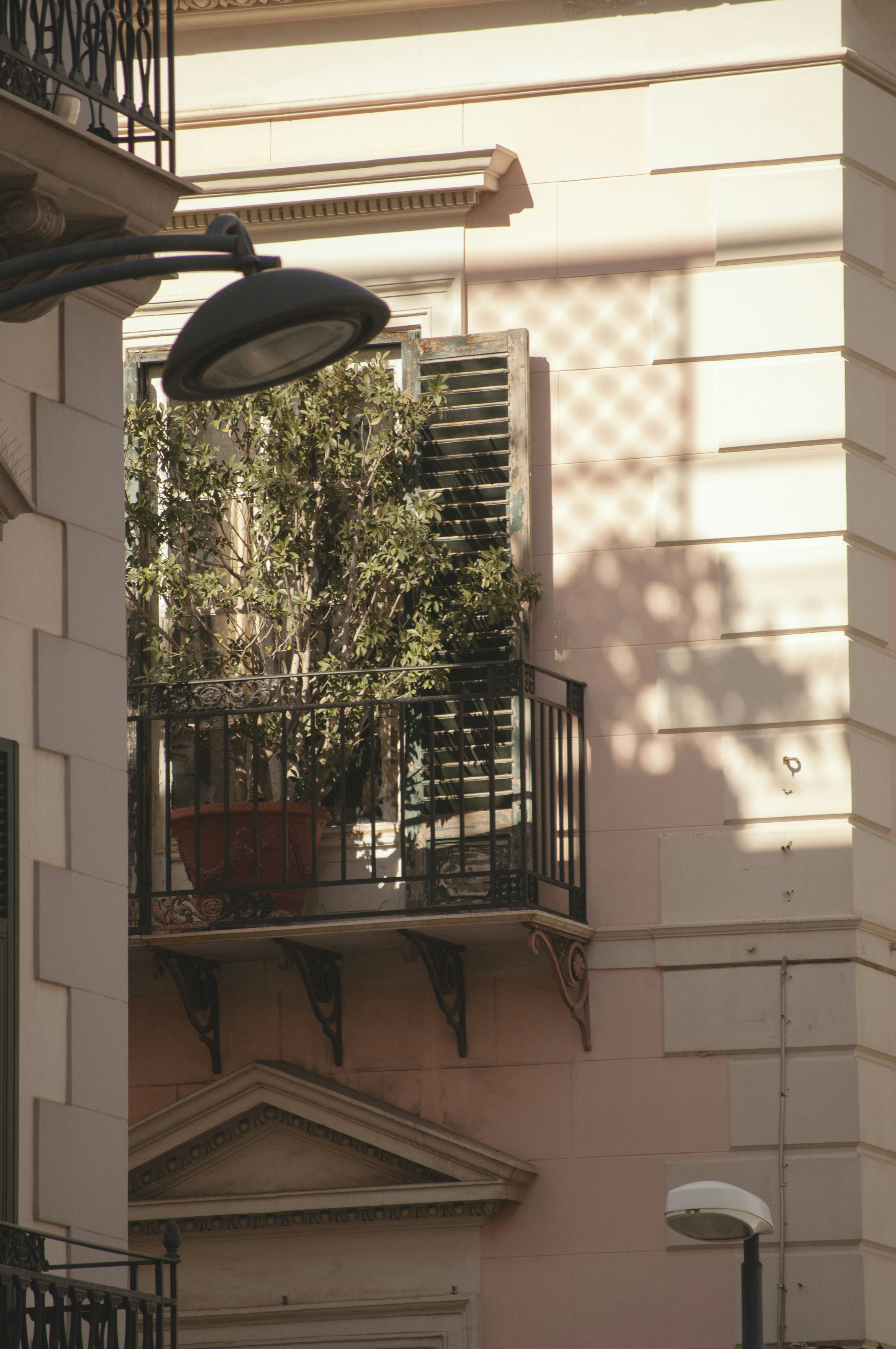 Feeder hanging from a balcony overlooking a garden