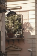 Close-up of a balcony secured with protective mesh, sunlight casting shadows