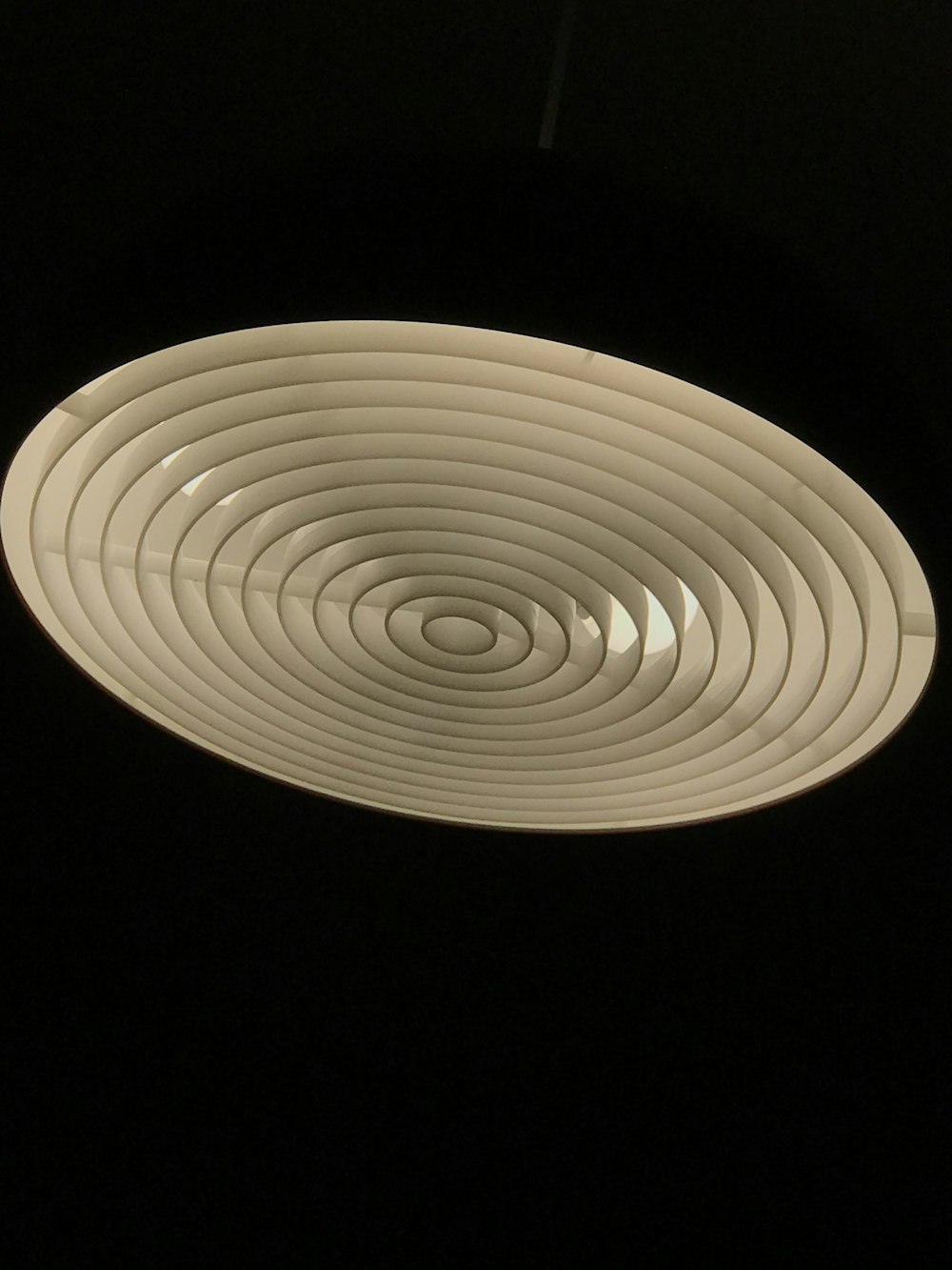 a white circular object hanging from a ceiling