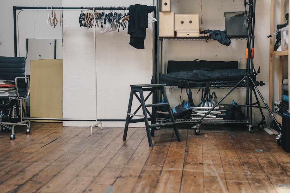 black stool beside clothes rack