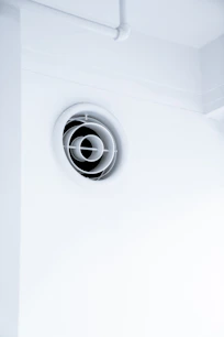 Modern ventilation system ductwork being installed in a bright, airy home interior.