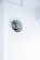 A circular ventilation duct is embedded in a white wall, featuring a series of concentric rings inside the vent. The surrounding area is clean and minimalistic with an overall bright appearance.