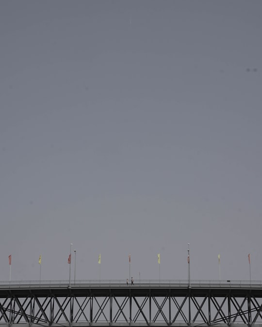 banners on gray metal bridge under gray sky in Constância Portugal