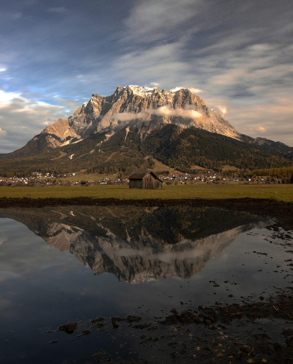 reflection of gray mountain on body of water during daytime