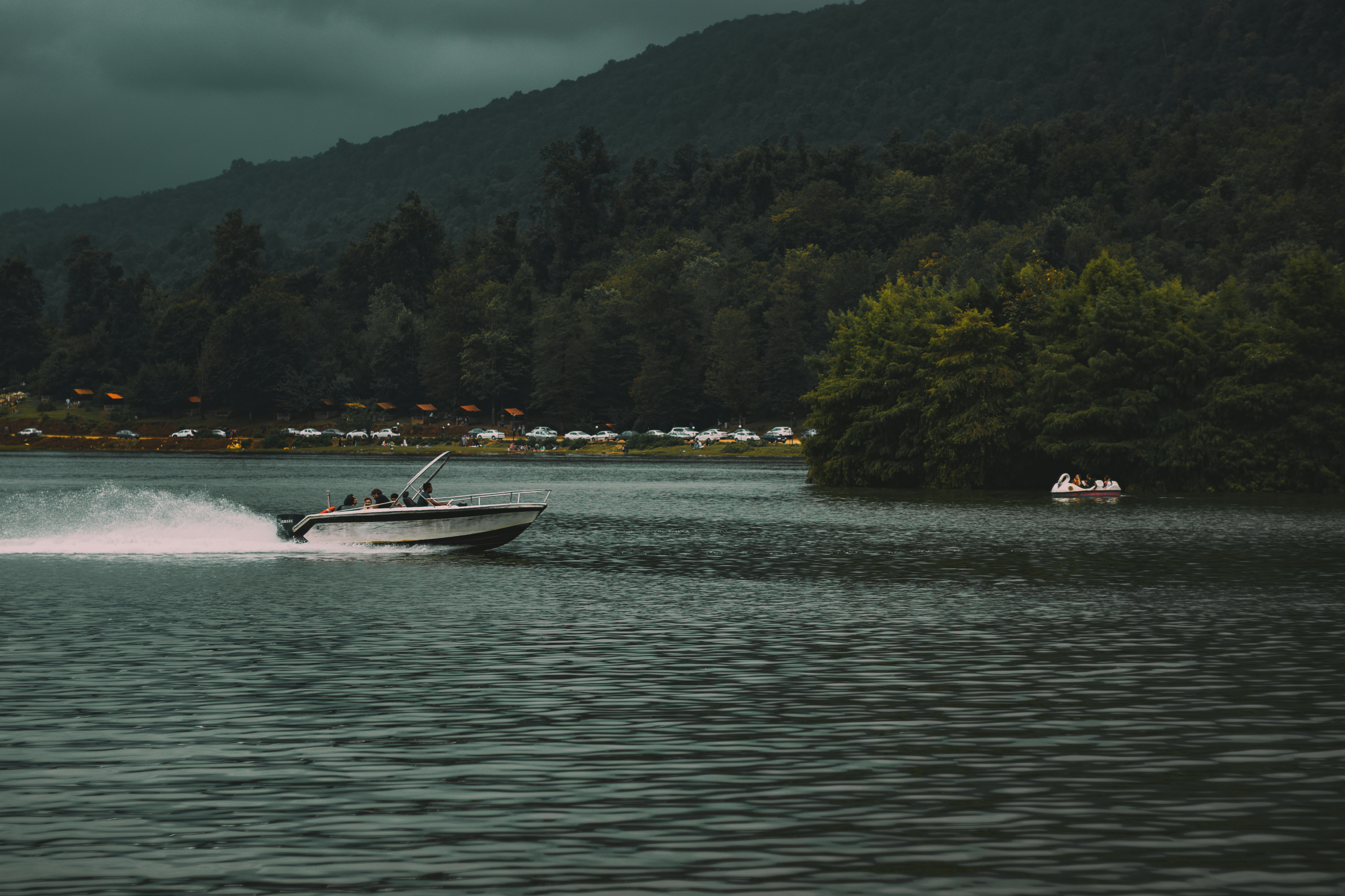 white motorboat on calm body of water during daytime