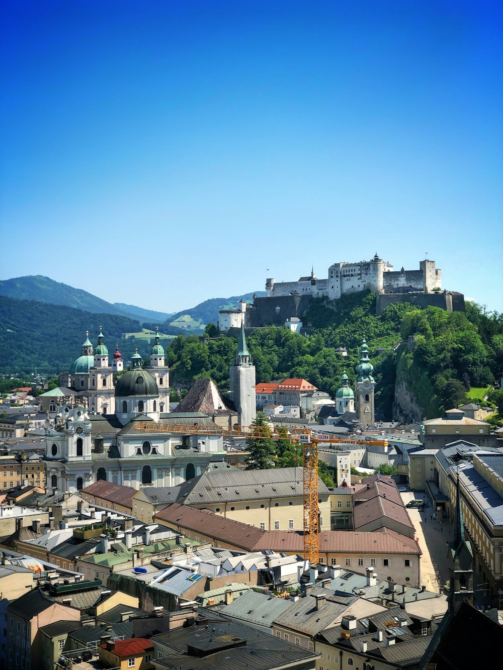 city with high-rise buildings and Castle in Salzburg, Austria viewing mountain and castle during daytime