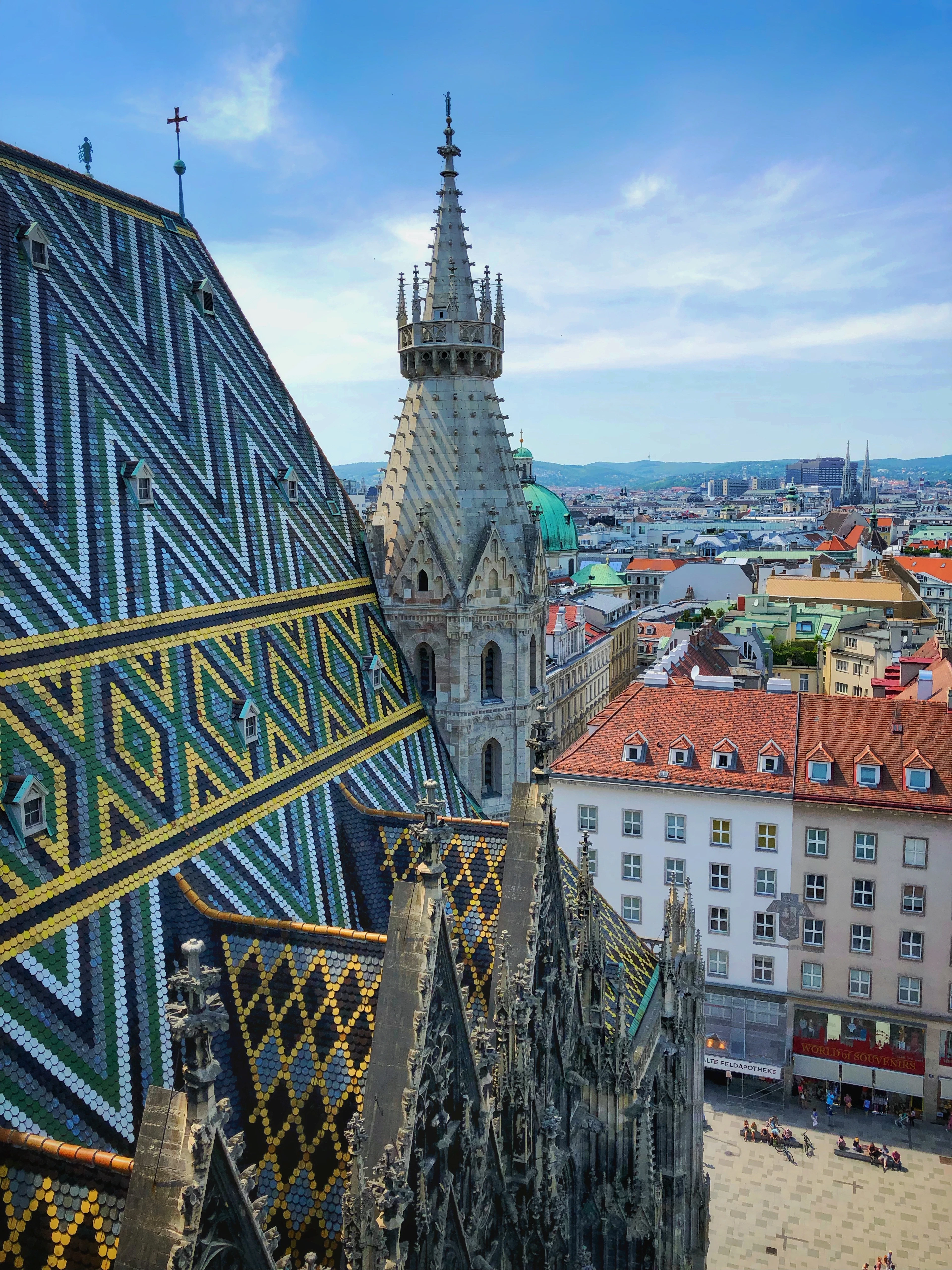 The patterned tiled roof of St Stephen's Cathedral in Vienna, the city's rooftops falling away beyond
