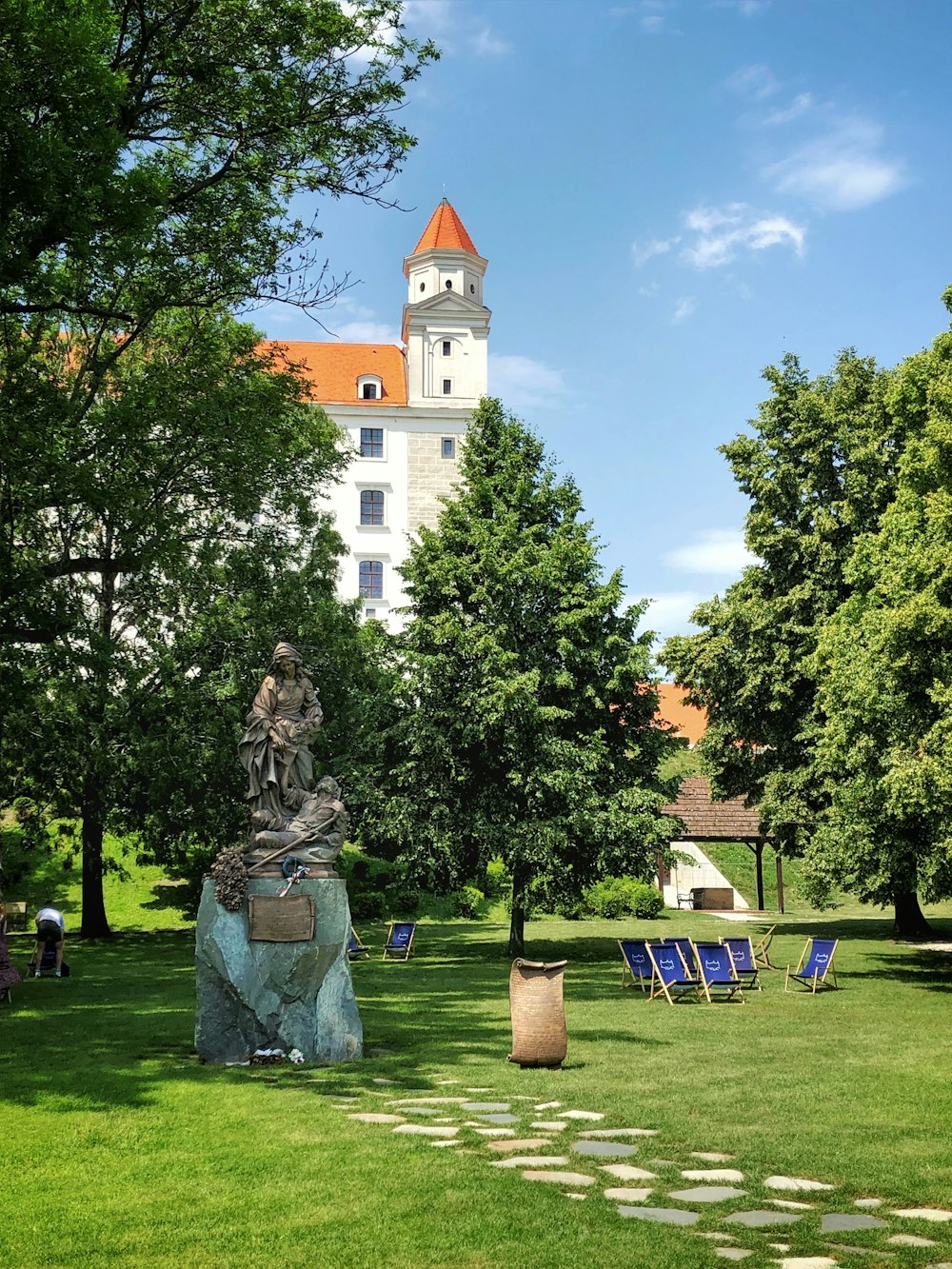 statue near trees and building during daytime